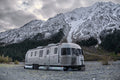 Grey AIRSKIRTS Inflatable Trailer Skirting Kit - Full Side View on Airstream in Snowy Mountains | United RV Parts